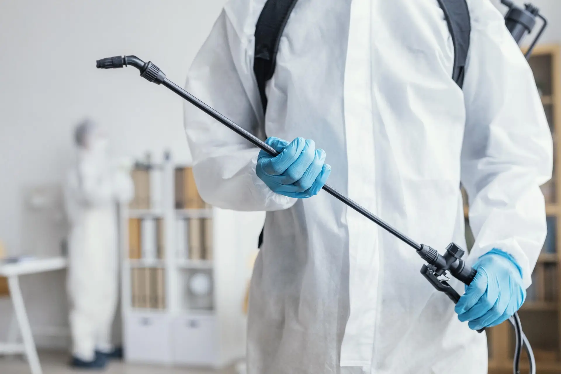 Melbuzz Pest Control technician using sprayer for flea treatment and removal in Melbourne homes.